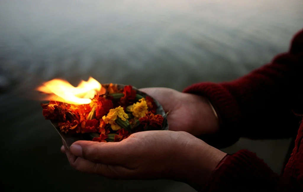 Devotees performing Ganga Aarti at Triveni Sangam during Maha Kumbh Mela 2025 in Prayagraj.