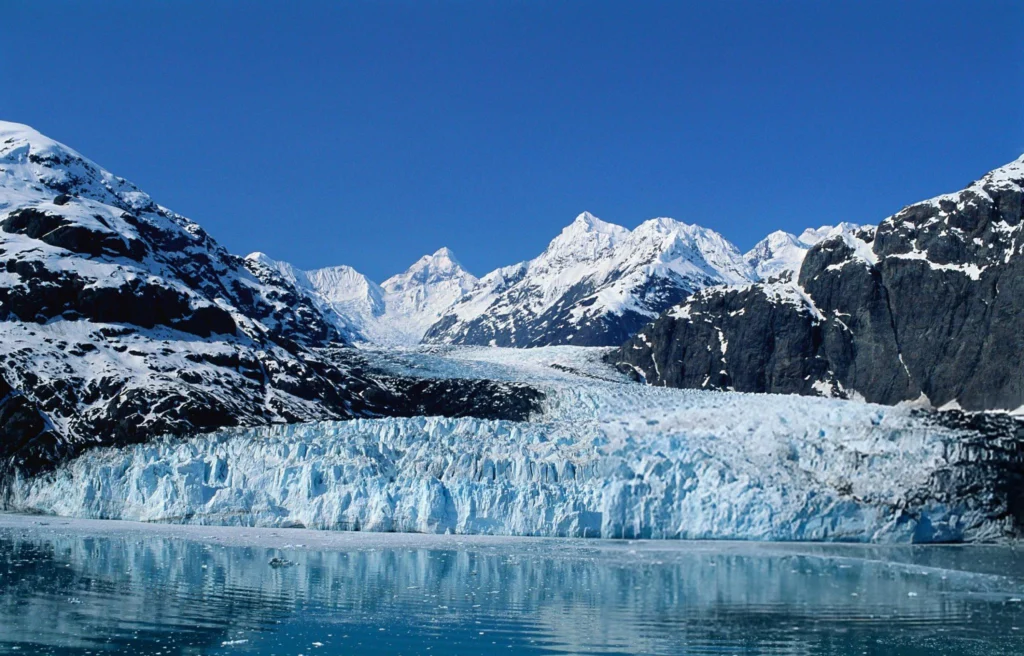 A panoramic view of Sonmarg with glaciers, snow-capped peaks, and green meadows.
